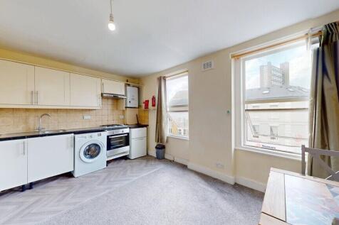 Bright and tidy kitchen area featuring modern a...