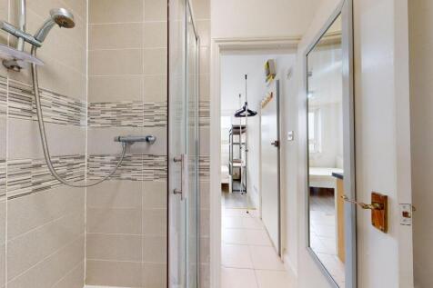 Modern bathroom featuring a shower with beige t...