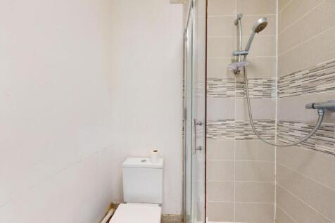A clean, modern bathroom with a shower area fea...