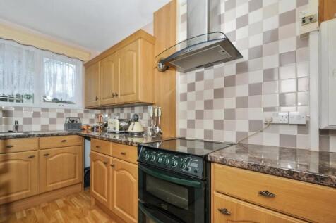 A bright and tidy kitchen featuring ample woode...