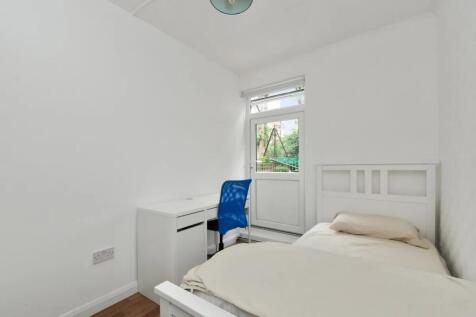 A bright and clean single bedroom with white wa...
