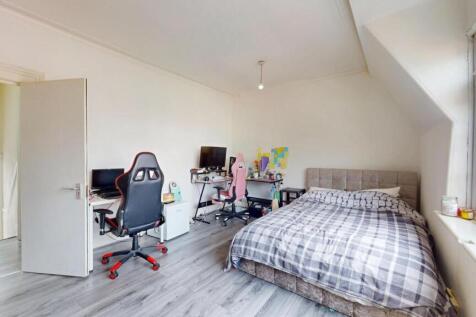 A bright and spacious bedroom featuring a comfo...