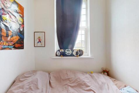 Cozy bedroom featuring a soft bed with light be...