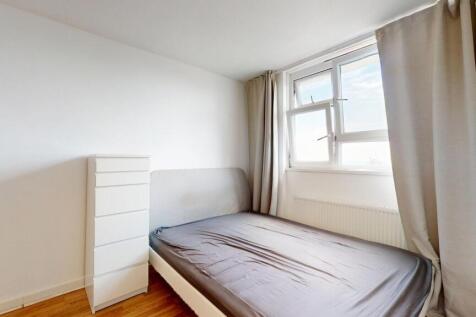 Bright, simply furnished bedroom with a double ...