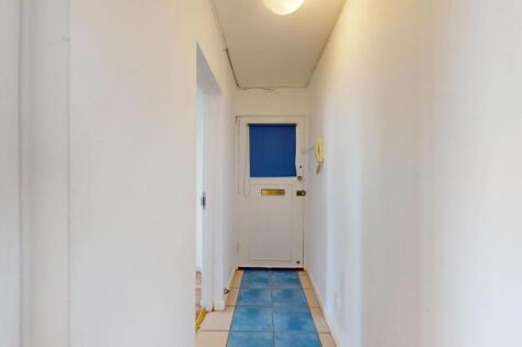 Narrow bright hallway with white walls, a ceili...