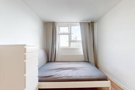 Bright, simply furnished bedroom with a double ...