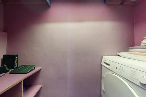 Compact utility/storage room with built-in shel...