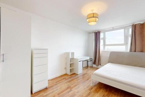 Bright, neatly furnished bedroom with a large w...