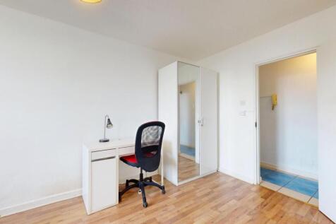 Bright, simply furnished bedroom with laminate ...