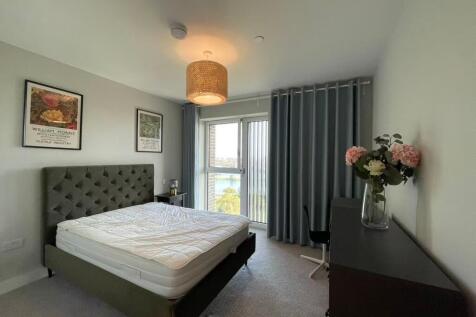 Bright, modern bedroom with a tufted upholstere...