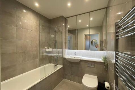 Modern fully tiled bathroom with a combined bat...