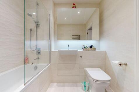 Bright, modern bathroom with a bathtub and show...