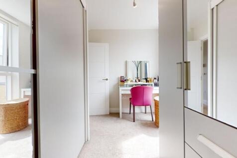 Bright, modern bedroom with built-in storage an...