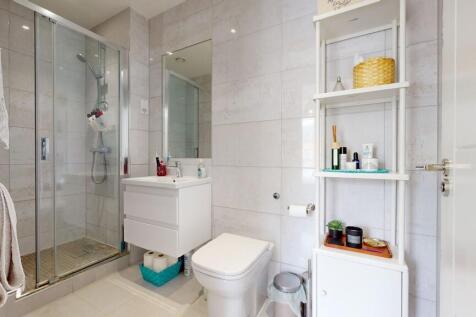 Bright, modern bathroom with a glazed shower en...