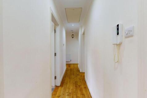 Bright, neatly presented hallway with warm wood...