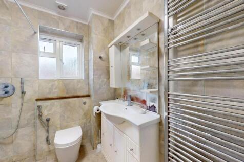Bright, modern bathroom with tiled walls, a van...
