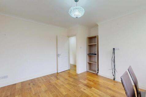 Bright, neutral living area with warm wood floo...