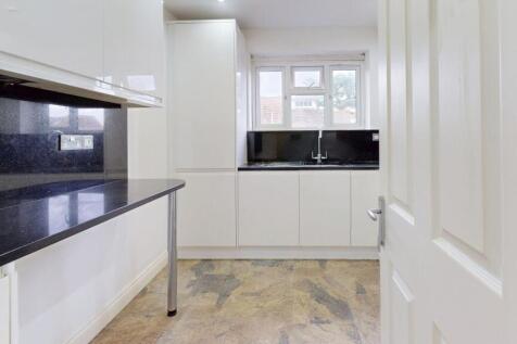 Bright modern kitchen with sleek black countert...