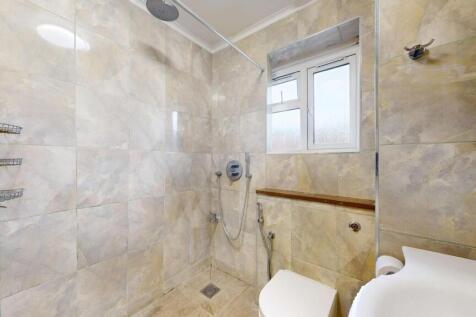 Modern tiled bathroom with an open shower area,...