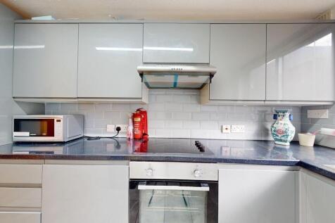 Modern fitted kitchen with glossy upper cabinet...