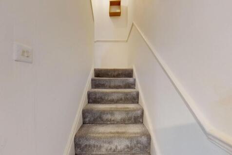 Carpeted interior staircase with neutral white ...