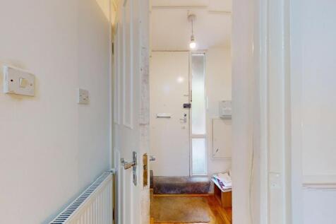 Bright entrance hallway with a secure front doo...