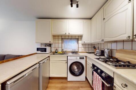 Bright, well-equipped kitchen with cream cabine...