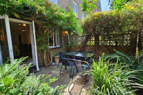 Sunny private patio garden with outdoor dining ...