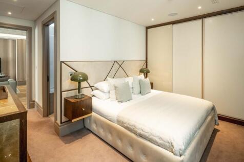 Stylish master bedroom with a plush upholstered...