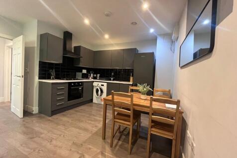 Modern open-plan kitchen with sleek dark cabine...
