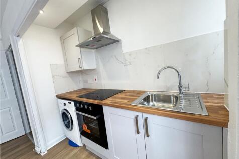 Bright modern galley-style kitchen with wood-ef...
