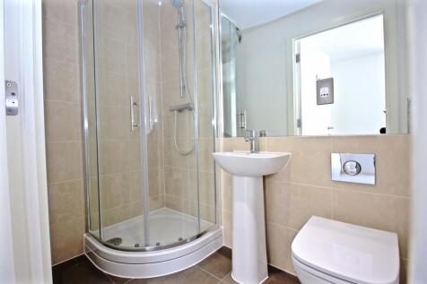 Bright, modern bathroom with a corner glass sho...