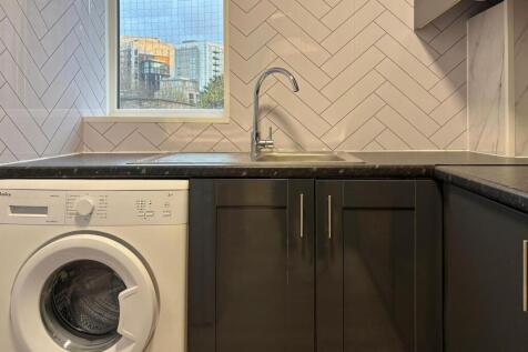 Modern kitchen with a sleek black countertop, s...