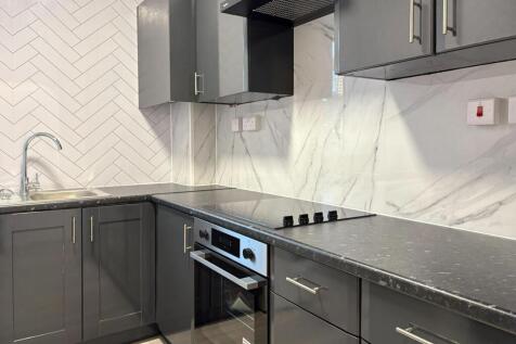 Modern fitted kitchen with dark grey cabinets, ...