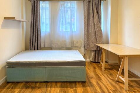 Bright, simply furnished bedroom with a double ...