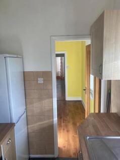 A compact kitchen featuring a tall white refrig...