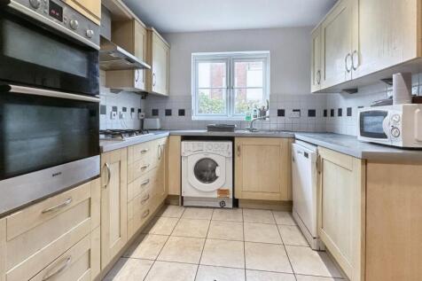 A tidy and well-lit kitchen with modern applian...