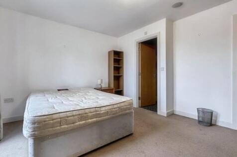 A partially furnished double bedroom with a mat...