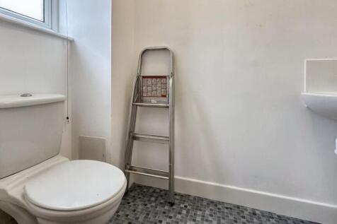 A clean but small bathroom featuring a shower a...