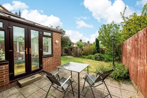 A well-maintained garden with a patio table and...