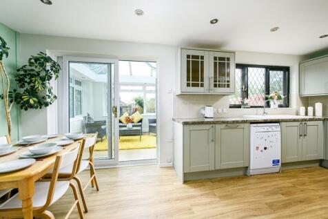 A bright and tidy kitchen with a dining area, f...