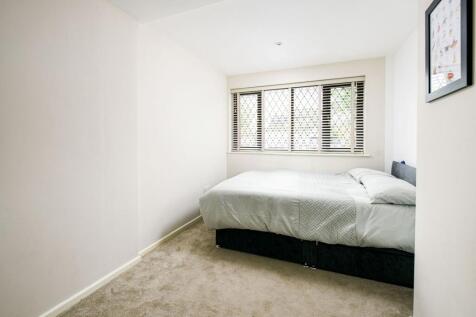 A clean and well-lit double bedroom with large ...