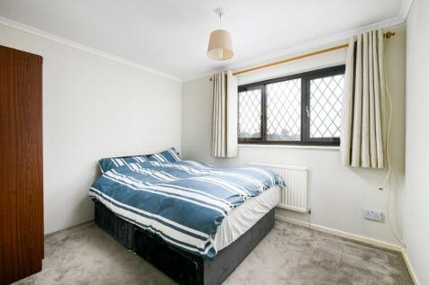 A tidy double bedroom with natural light from a...