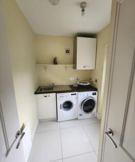 Bright and tidy laundry room featuring modern w...
