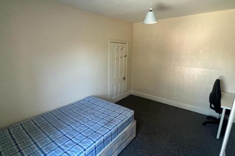 A spacious double bedroom with a comfortable be...