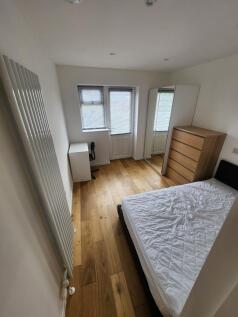 A neat and bright double bedroom featuring warm...