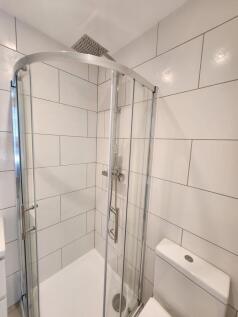 A modern bathroom featuring a sleek corner show...