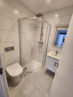Modern bathroom featuring a curved glass shower...