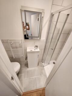 Bright and modern bathroom featuring a glass-en...