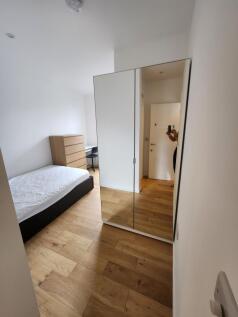A bright and tidy single bedroom featuring a wo...